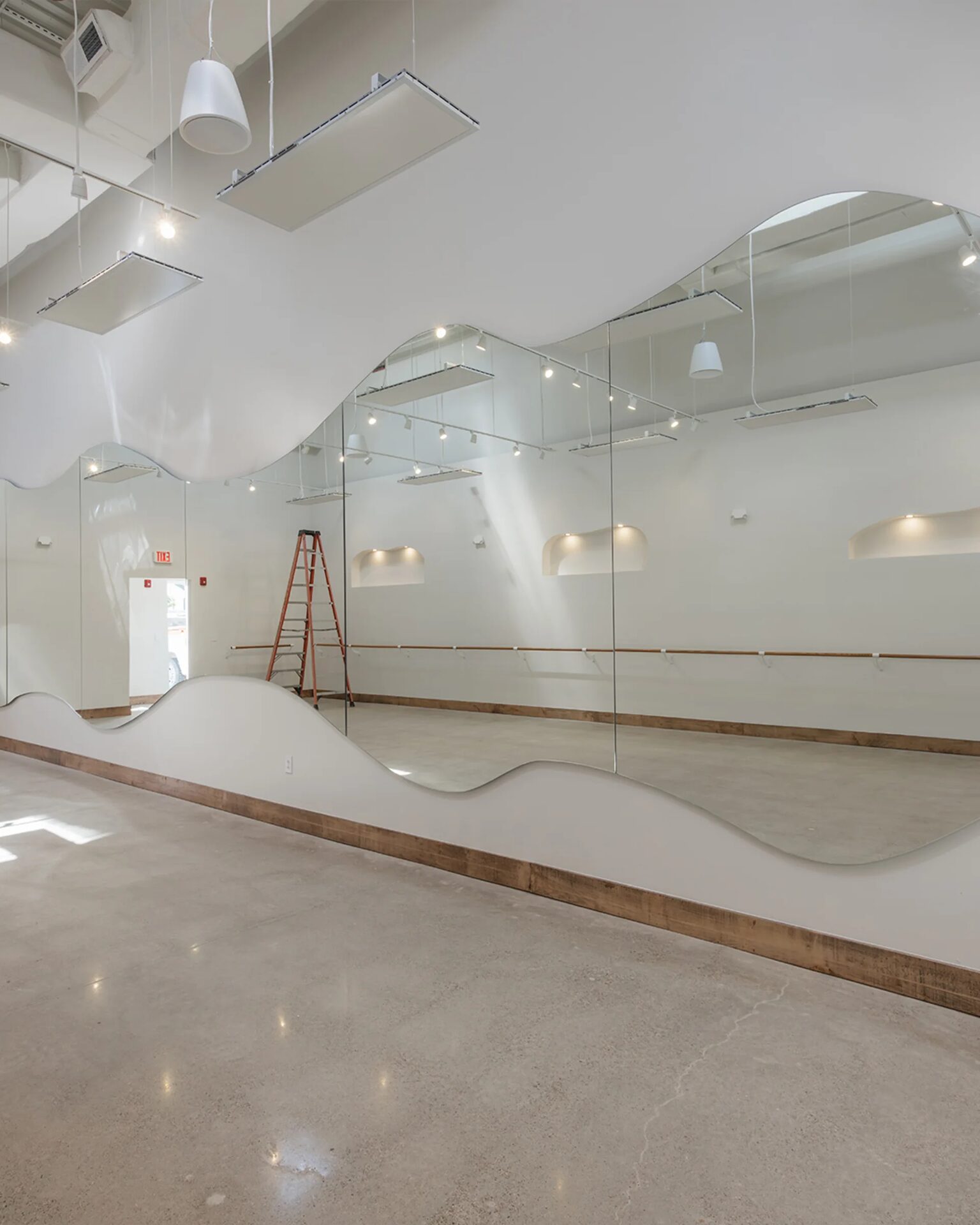 Curved tempered-mirror feature wall in a specialty interior space